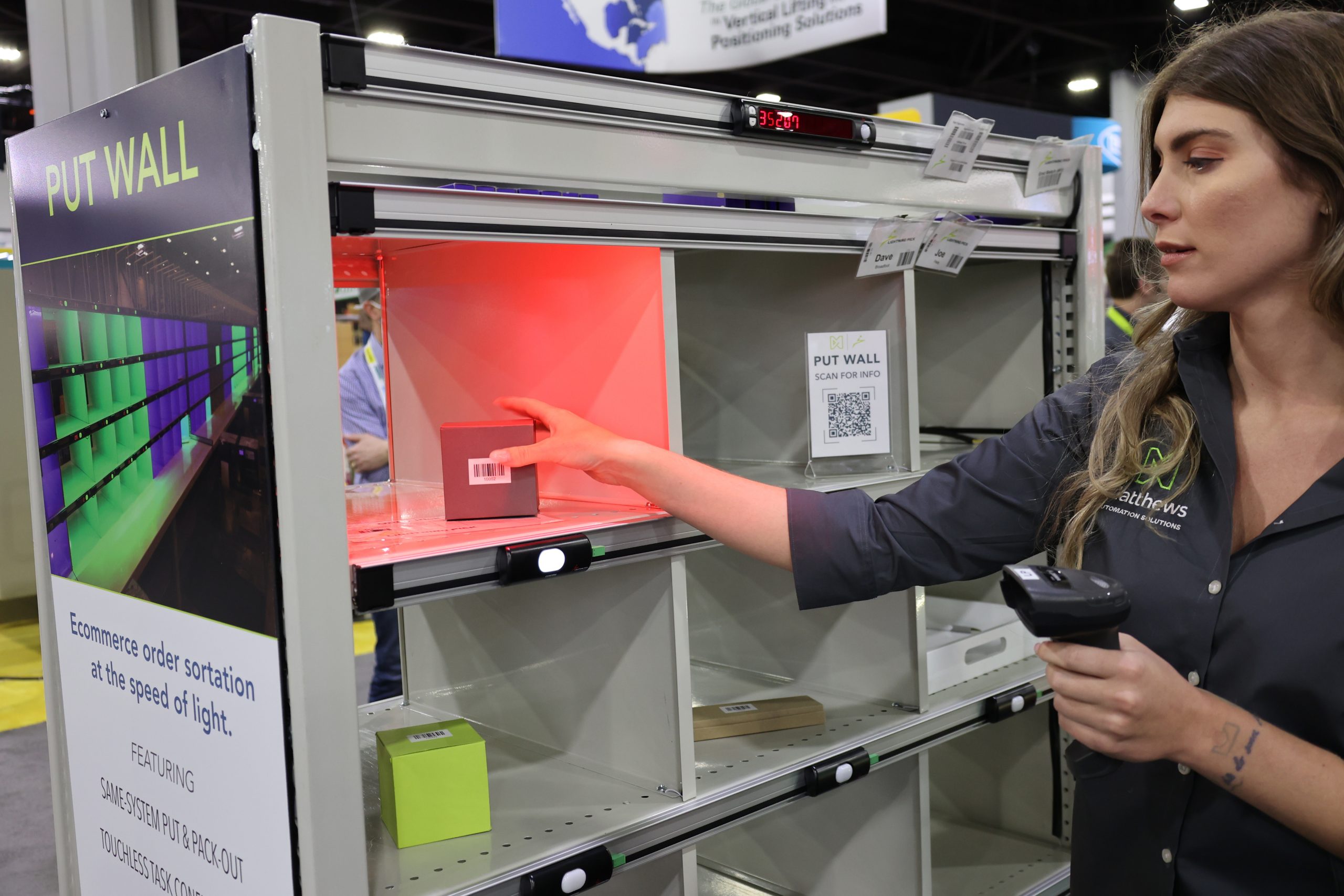 Operator performing put-to-light demo with bin illumination in a trade show booth