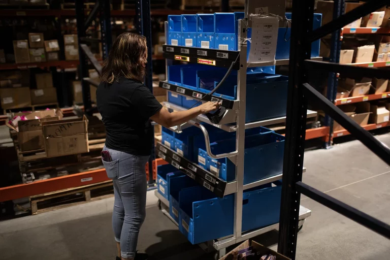 Woman using a picking cart at a 3PL.